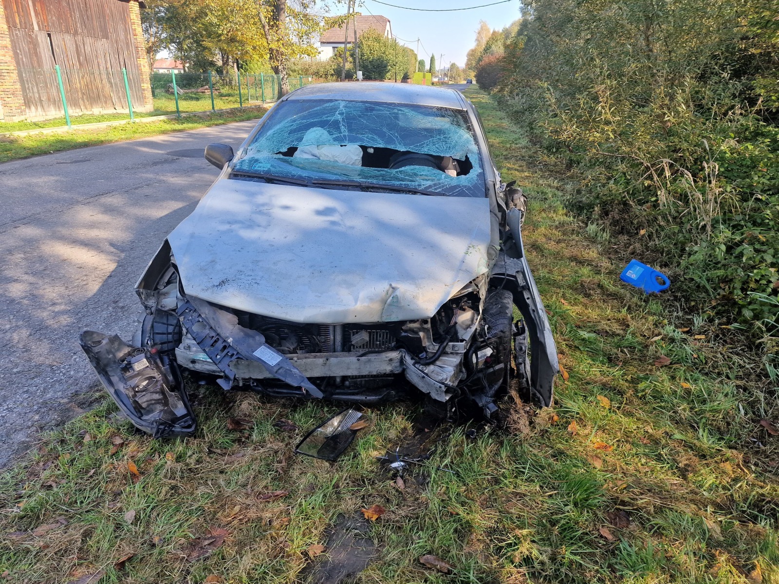 Opel wypadł z jezdni, uderzył w ogrodzenie posesji, a następnie wywrócił się na bok