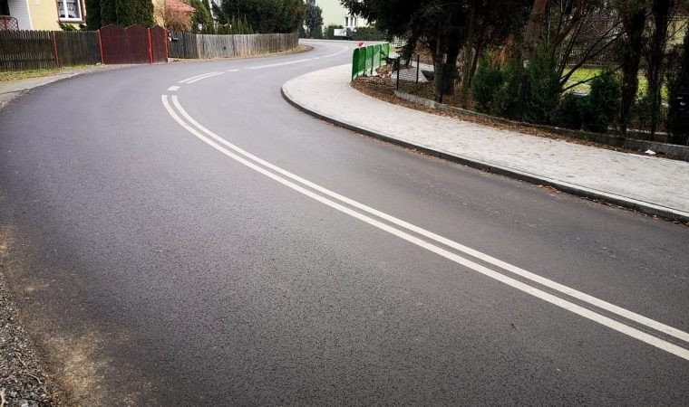 Łukowaty odcinek ulicy Grojeckiej w Zaborzu z nową nawierzchnią i chodnikiem